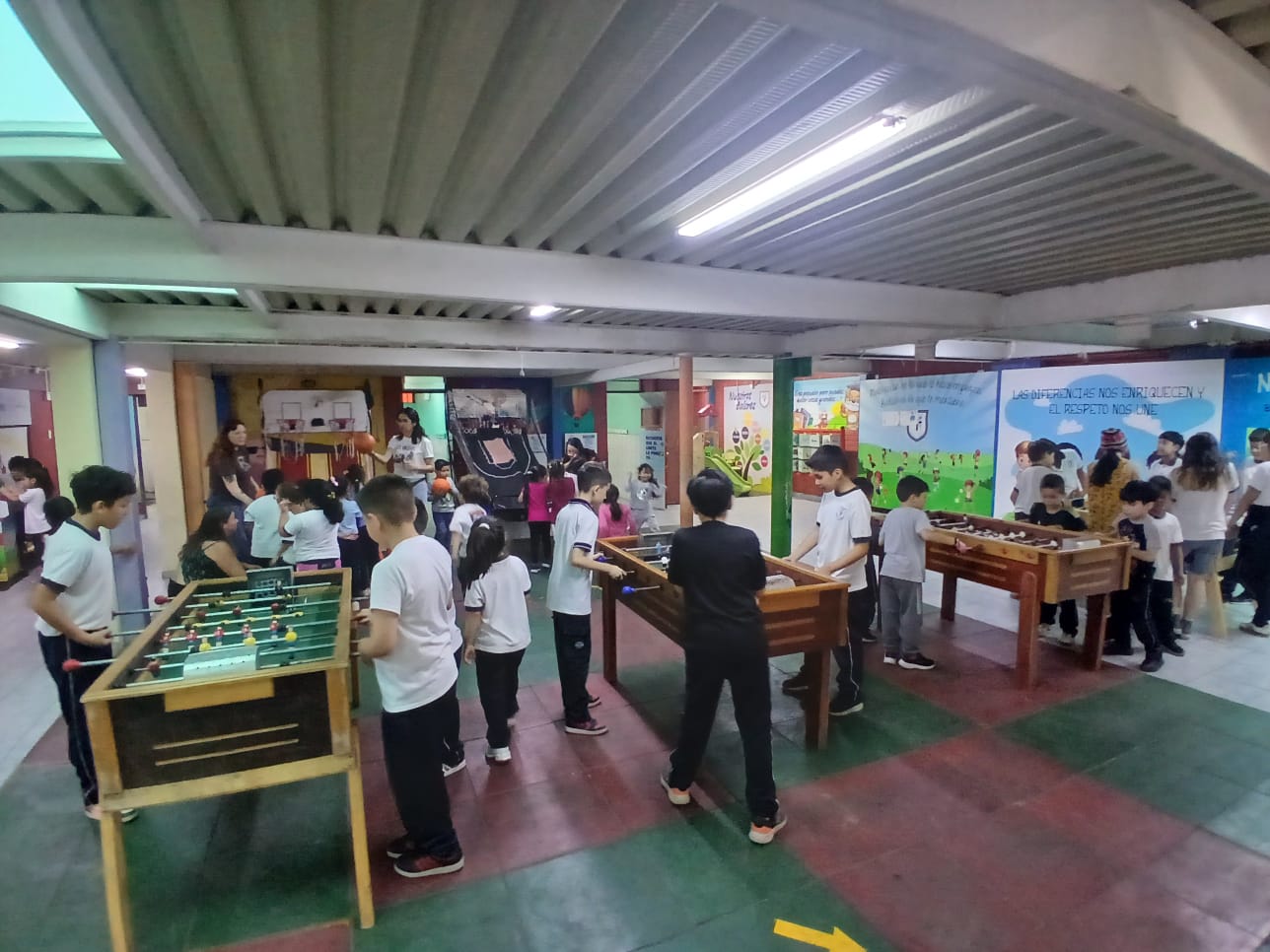 Niños jugando futbolín en evento escolar
